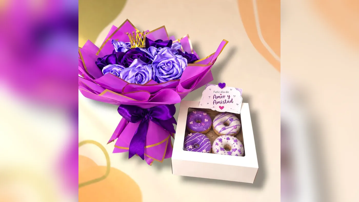 Buchón bouquet of purple and lilac eternal roses with a gold crown, next to a box of four purple decorated donuts with a friendship day card, Detalles de Amor Medellín