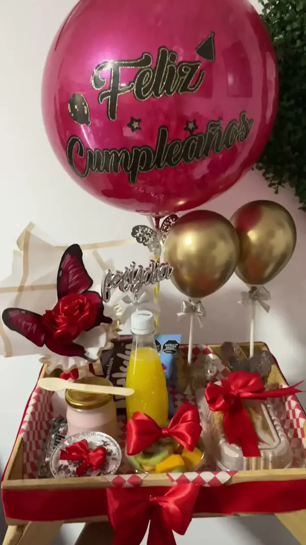 Birthday surprise breakfast on a wooden tray with fresh juice, fruit, pastries and balloons — Detalles de Amor Medellín
